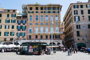a group of buildings in a city with people walking around at The Seven Mansions in Genoa