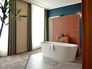a bathroom with a white tub in a room at Fletcher Hotel Paleis Stadhouderlijk Hof in Leeuwarden +75 photos
