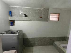 a small bathroom with a sink and a washing machine at SM GARDENS Nature Stay Kodaikanal in Oothu