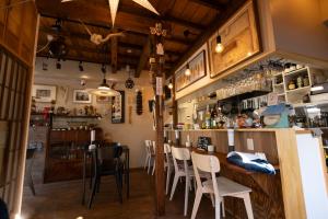 a restaurant with a bar with white chairs at 千寿宿 玄 in Tokyo