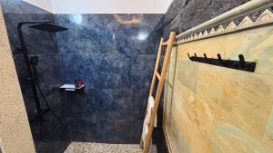 a bathroom with a shower and a black wall at ABG Villas - Agrowisata Amed in Amed
