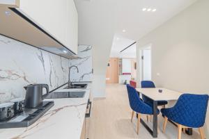 a kitchen with a dining table and blue chairs at Evianamar in Shëngjin