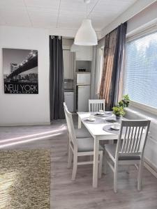 a dining room with a white table and chairs at Hamina Comfort Apartment in Hamina +7 photos