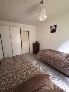 a bedroom with two beds and a chandelier at Hamina Comfort Apartment in Hamina