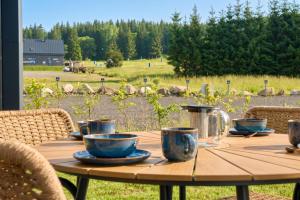 a wooden table with cups and teapots on it at Apartmány Krušec by Mountain ways in Plešivec