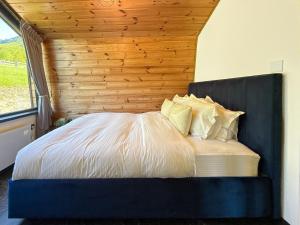 a bed in a room with a wooden wall at Forest Cuib in Predeluţ