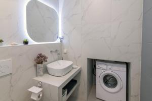 a bathroom with a washing machine and a sink at Aegean Whispers in Agios Fokas +26 photos