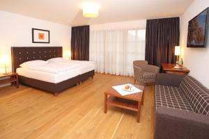 una camera d'albergo con letto e divano di Hotel Hochsteg Gütl | Traunsee Salzkammergut a Ebensee