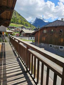 a wooden walkway with a view of a mountain at Large Superior Style Chalet - Central Location in Morzine