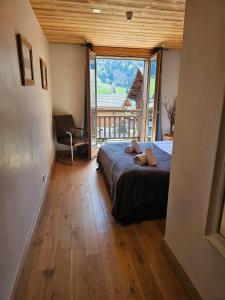 a bedroom with a bed and a large window at Large Superior Style Chalet - Central Location in Morzine