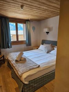 a bedroom with a large bed with a wooden ceiling at Large Superior Style Chalet - Central Location in Morzine +5 photos