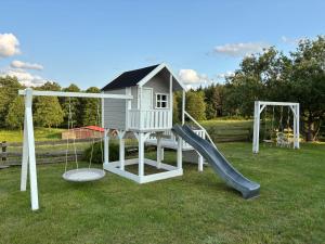 a playground with a slide and a play house at Babie Lato in Mrągowo