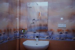 a bathroom with a sink and a mirror at Jaffna Gateway Hotel and Restaurant in Kanakarayankulam