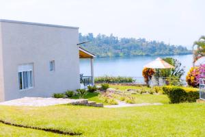 a yard with a house and a view of a lake at Mariebu Beach Resort in Buhongo