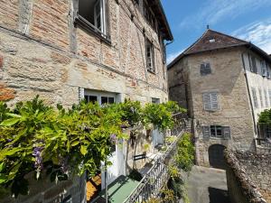 an old stone building with plants on a balcony at Le Soleilho in Figeac
