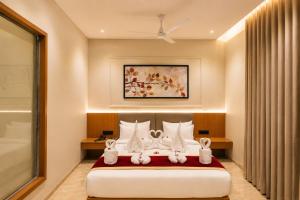 a bedroom with a bed with two rabbits on it at LUXURIA INN By CHANDAN in Junagadh +26 photos