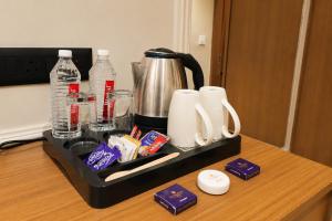 a tray with a coffee maker and drinks on a counter at LUXURIA INN By CHANDAN in Junagadh