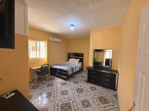 a bedroom with a bed and a mirror and a desk at Guest House A&H - Boca Chica Beach & Airport in Boca Chica