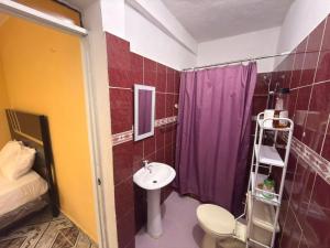 a bathroom with a purple shower curtain and a sink at Guest House A&H - Boca Chica Beach & Airport in Boca Chica +27 photos