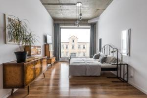 a bedroom with a bed and a large window at Gold and Silver Apartment - Manu SPA Lofts in Łódź