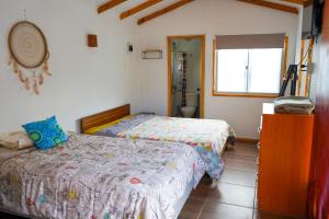 a bedroom with two beds and a window at Río Luna cabaña 2 in Diaguita