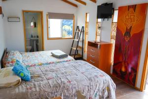 a bedroom with a bed and a painting on the wall at Río Luna cabaña 2 in Diaguita