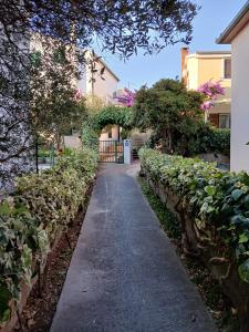 a walkway through a garden with trees and bushes at Rooms LuaMar in Sali