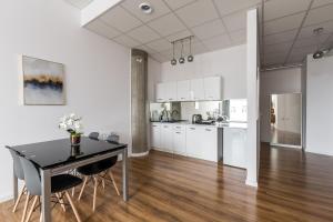 a kitchen and dining room with a table and chairs at Gold and Silver Apartment - Manu SPA Lofts in Łódź +13 photos