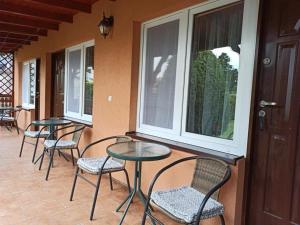 a row of tables and chairs on a porch at Pokoje na Okrężnej in Białogóra