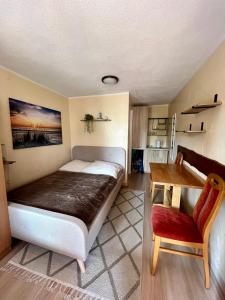 a bedroom with a bed and a table and a chair at Pokoje na Okrężnej in Białogóra
