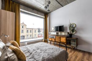a bedroom with a bed and a large window at Gold and Silver Apartment - Manu SPA Lofts in Łódź