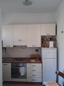 a kitchen with white cabinets and a stove top oven at Casa Sirente, Via Monte Sirente n 51 in Francavilla al Mare