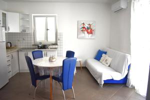 a living room with a table and chairs and a couch at Apartmani Benedetti in Povljana