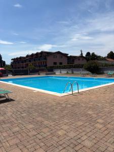 a large swimming pool in a courtyard with a building at Residence Malpensa in Somma Lombardo
