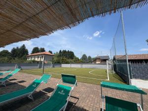 a tennis court with chairs and a soccer field at Residence Malpensa in Somma Lombardo