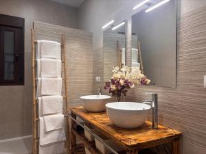 a bathroom with two white sinks on a wooden counter at El rincón de San Bartolomé in Jerez de los Caballeros