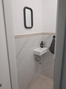a white bathroom with a sink and a mirror at Self Check-in Apartment DLT - Free Parking in Sankt Marein im Mürztal +6 photos