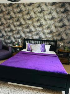 a bedroom with a purple bed with a wall at Pensão Simão & Júlia - 8 Quartos in Órgãos +36 photos