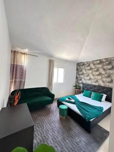 a bedroom with a green bed and a couch at Pensão Simão & Júlia - 8 Quartos in Órgãos