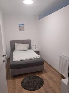 a small bedroom with a bed and a rug at Self Check-in Apartment DLT - Free Parking in Sankt Marein im Mürztal