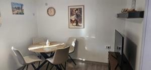 a dining room with a table and chairs and a clock at Студио МИНЕРА in Kyustendil