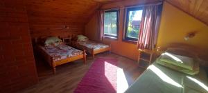 a room with two beds and two windows at Vīteri 1 in Labvārži