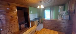 a kitchen with wooden walls and a sink in a room at Vīteri 1 in Labvārži