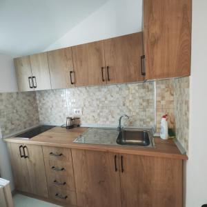 a kitchen with wooden cabinets and a sink at Bujari Guesthouse in Berat