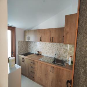 a kitchen with wooden cabinets and a sink at Bujari Guesthouse in Berat +20 photos