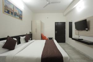 a bedroom with a large bed and a flat screen tv at Ritz The Boutique Hotel in Rohtak