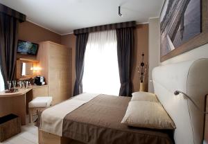 a hotel room with a bed and a window at Hotel C'era Una Volta in Castiglione della Pescaia