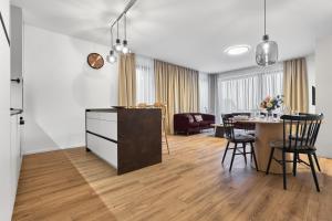 a kitchen and dining room with a table and chairs at Apartmány Krušec by Mountain ways in Plešivec