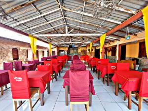 a row of red chairs and tables in a restaurant at Pousada Açaí in Salvaterra