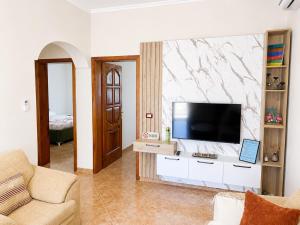 a living room with a flat screen tv on a wall at Villa Ajla- Entire Villa in Durrës